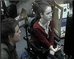 Claire sitting in a relaxed position, even though she is concentrating on eye-typing